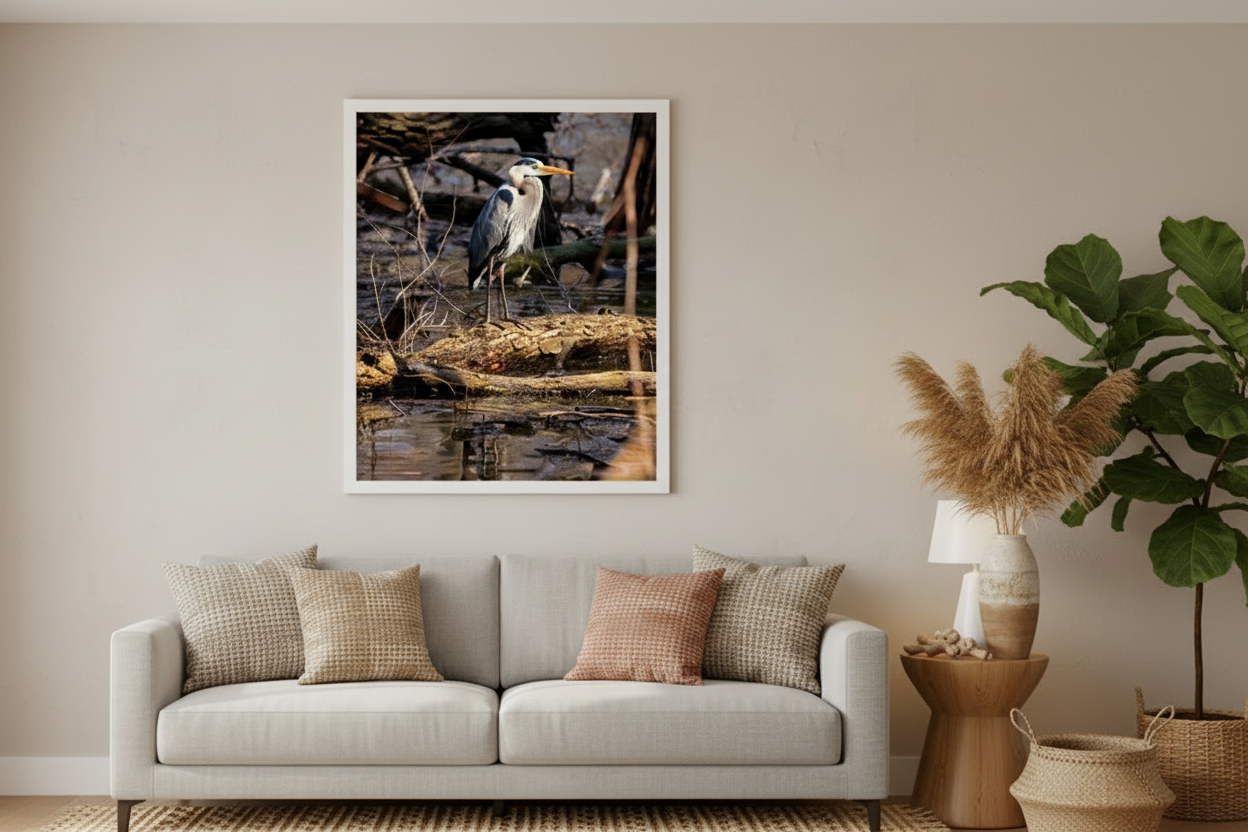 Living room with a gray sofa, decorative pillows, a framed nature photograph, and plants.