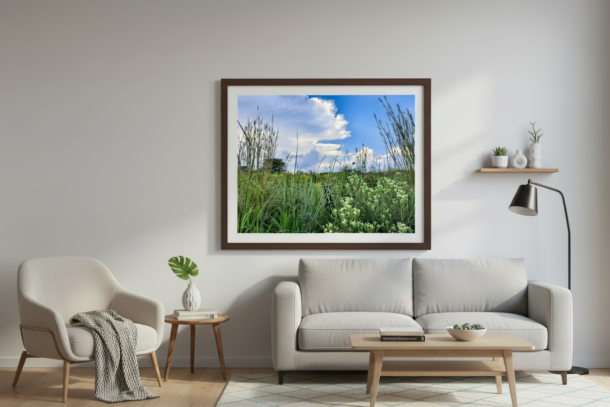 Living room with a gray sofa, armchair, coffee table, and framed landscape picture on the wall.