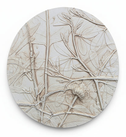 Round decorative plaster plaque with bas relief botanical leafs and branch patterns.
