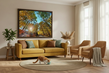 Framed Photo print of sun shining through fall tree leaves hanging on the wall of a Living room with yellow sofa, armchair, and decorative elements.