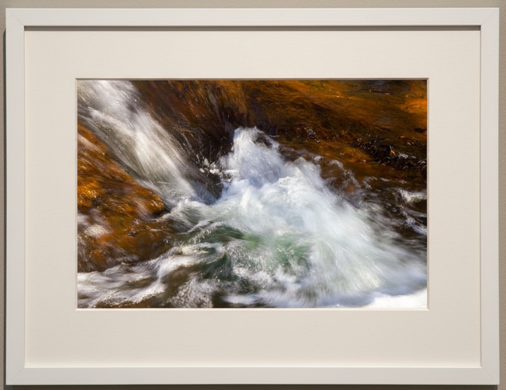 Framed photograph of a waterfall with a neutral background