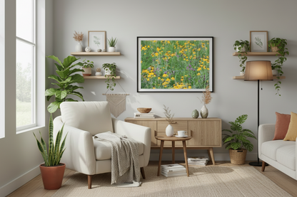 Framed photo print of iowa prairie in a Living room with a white armchair, wooden side table, and decorative plants.