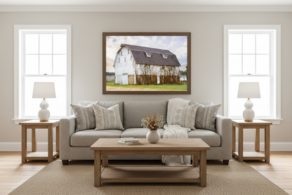 Living room with a gray sofa, wooden coffee table, and framed picture of a barn on the wall.