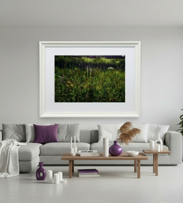 Framed nature print of an iowa prairie above a gray sofa in a living room.