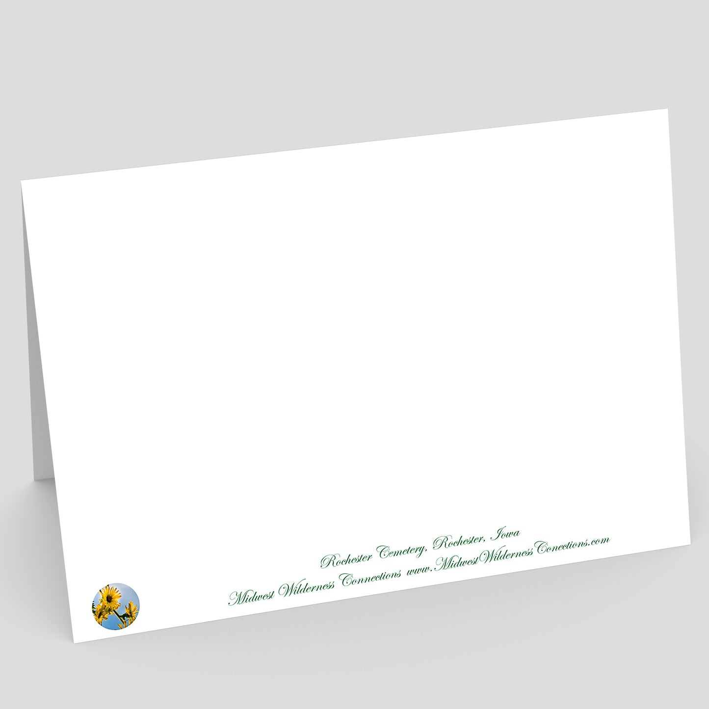 View of the backside of a White envelope with green text and a logo on a gray background. The text along the bottom edge describes the photo on the front of the card and where it was taken.