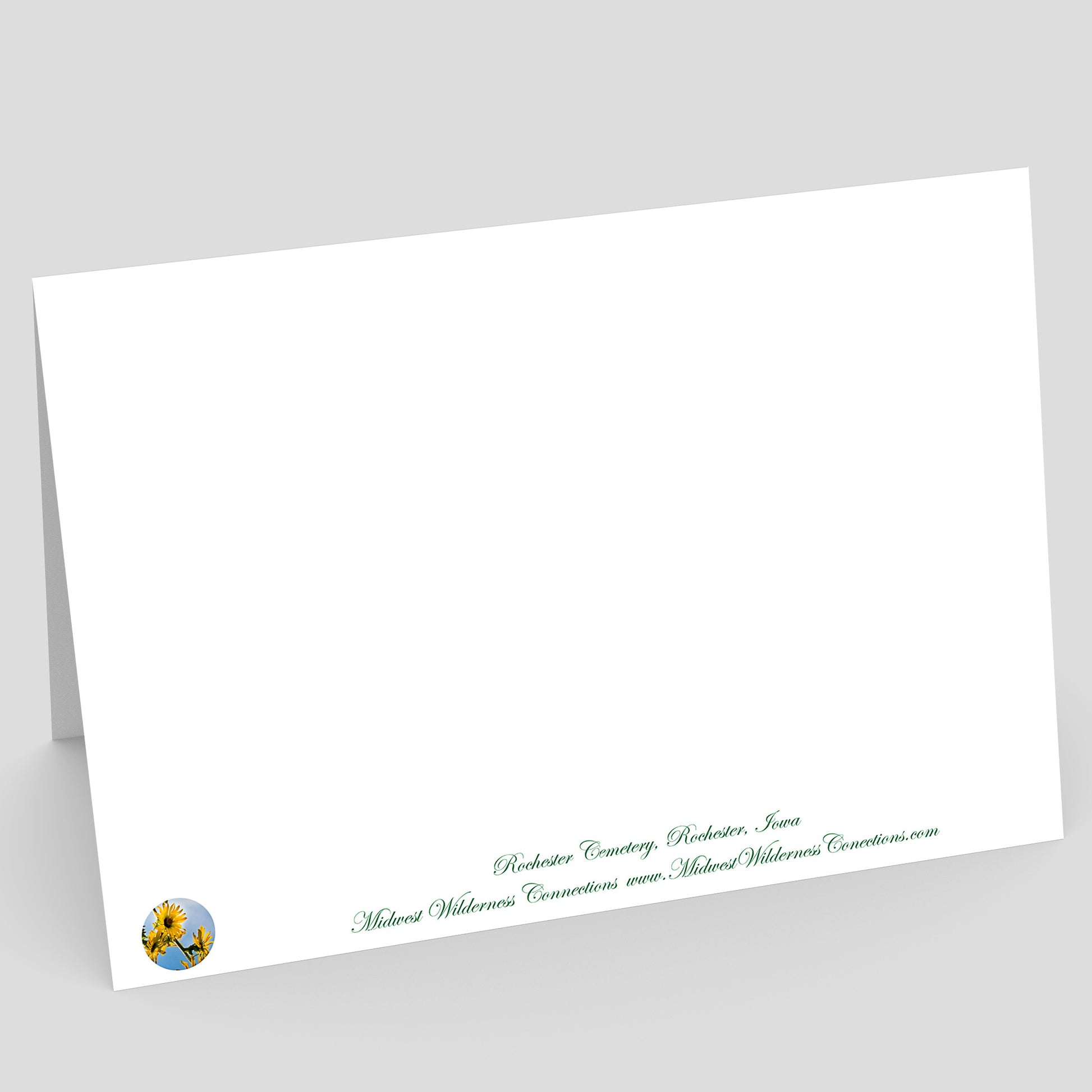 View of the backside of a White envelope with green text and a logo on a gray background. The text along the bottom edge describes the photo on the front of the card and where it was taken.