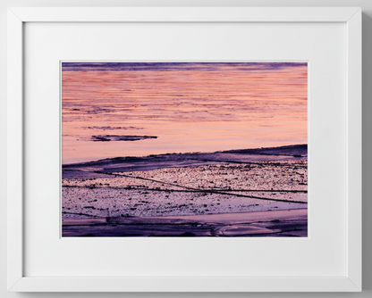 Framed artwork of a purple and pink sky reflecting on Mississippi River ice
