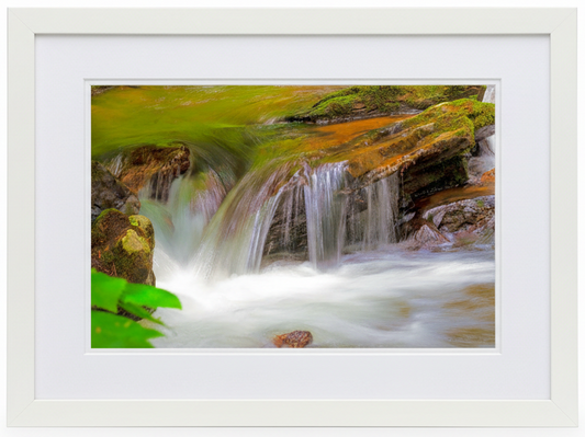 Framed photograph of a waterfall with a white frame