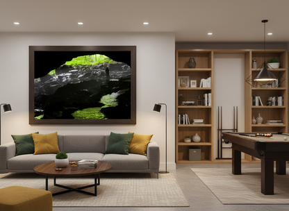 Modern living room with a gray sofa, coffee table, and wall art featuring a person standing in a cave