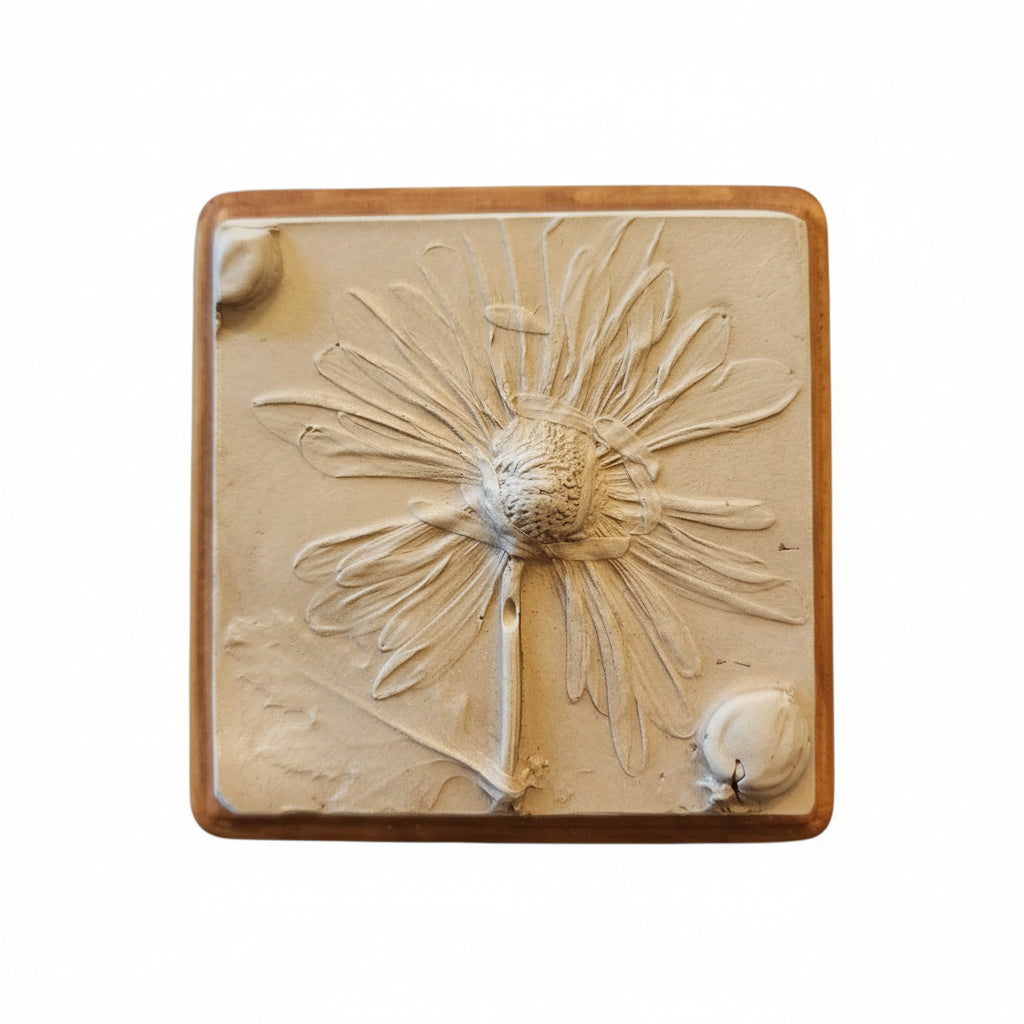 Square plaster cast of flowers mounted on an oak stained wood plaque
